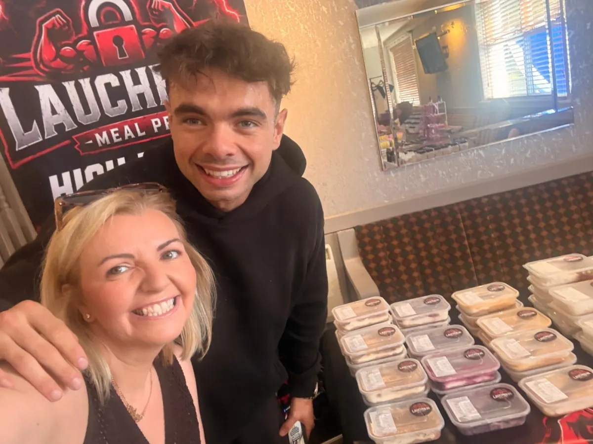 Two people at the stall with tubs stacked beside them